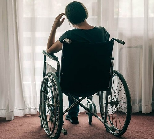 Person sitting alone in a wheelchair appearing depressed